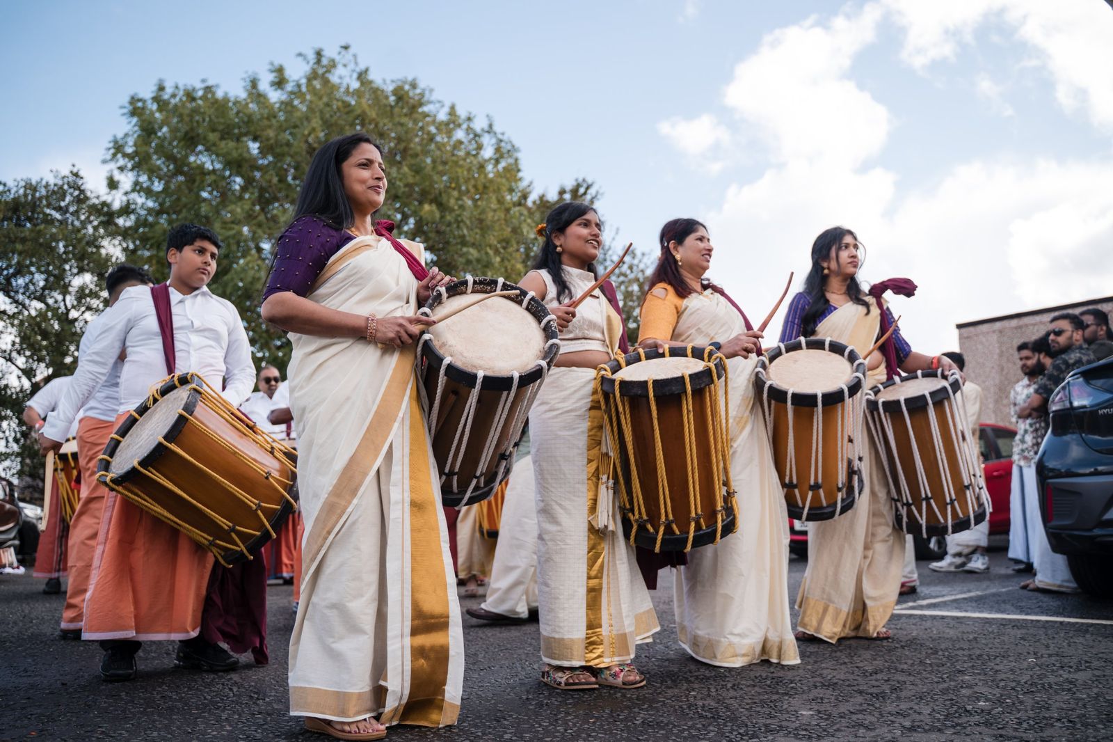 Women in kasavu sarees playing chenda drums